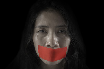 Unhappy woman with her mouth covered by tape