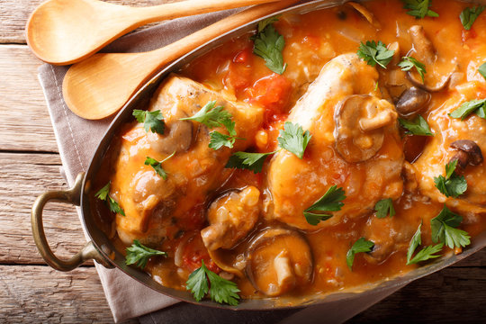 Chicken chasseur is a classic French dish with mushrooms and tomatoes in smooth sauce close-up. horizontal top view