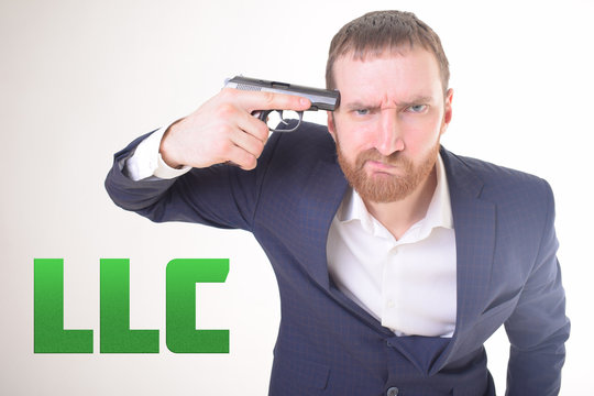 The businessman holds a gun in his hand and shows the inscription:LLC