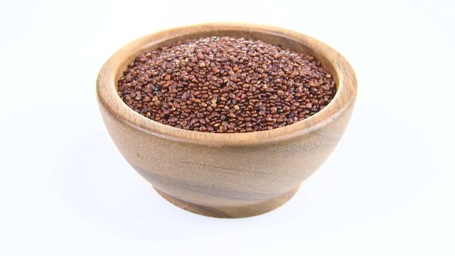 Quinoa in wooden bowl on white background. rotation
