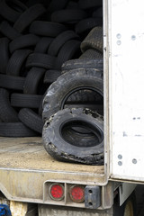 Old used tires are stored inside an old semi trailer with an open door