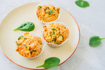 Savory potato spinach and feta muffins served on a plate. White stone background.