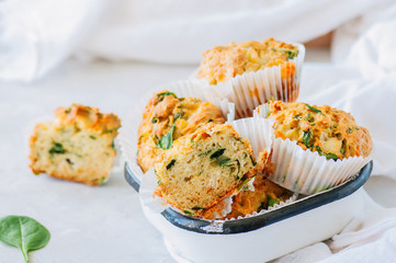 Savory potato spinach and feta muffins in a bowl. White stone background.