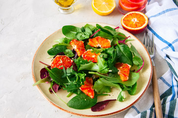 Fresh salad mix with blood oranges on a white stone background.  Top view. Healthy eating concept.