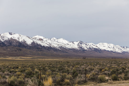 Snowcapped Mountains in Cloudy Desert Landscape