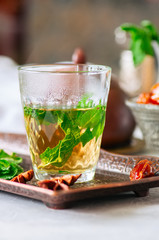 Traditional moroccan mint tea with dates on a vintage tray. White stone background.