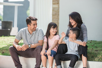 happy asian family in front of their house