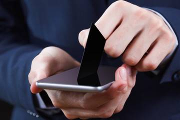 Hands holding mobile phone with isolated screen and credit card