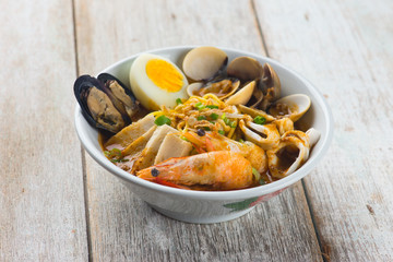seafood curry noodle with wood background