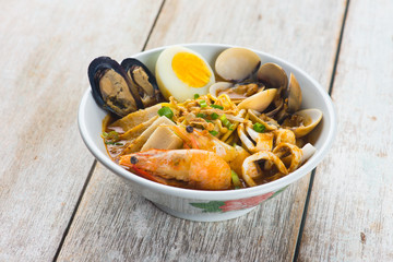 seafood curry noodle with wood background