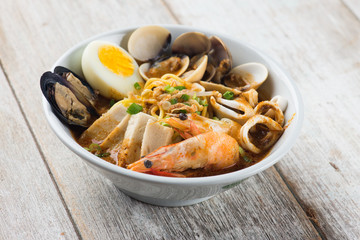 seafood curry noodle with wood background