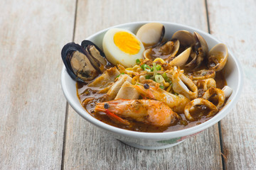 seafood curry noodle with wood background