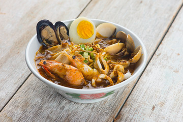 seafood curry noodle with wood background