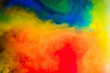 Fototapeta premium ink in the water. A splash of red, blue, yellow and green paint. Abstract background