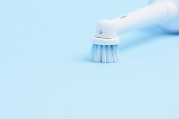 An electric toothbrush isolated on light blue background.