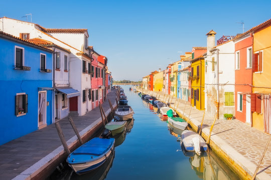 Fototapeta Beautiful colorful houses and a canal with boats in Burano, Venice