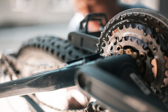 A Guy Athlete Serves And Repairs His Mountain Bike In The Garage