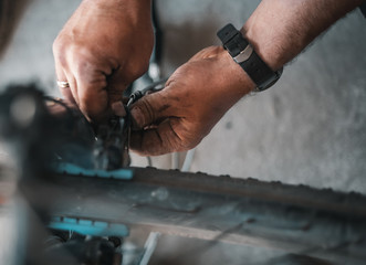 A guy athlete serves and repairs his mountain bike in the garage