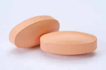 Pink pills and tablets isolated on white background