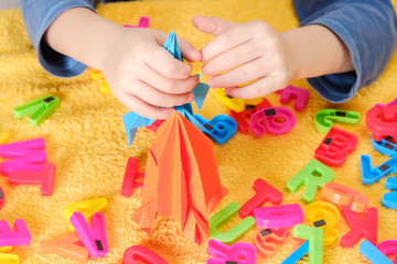 Little baby hand playing with colorful toys and letters