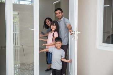 Fototapeta na wymiar happy family with kids open their house door 