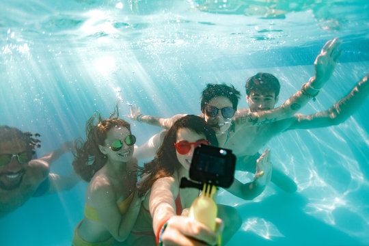 Friends taking selfie under the water in swimming pool