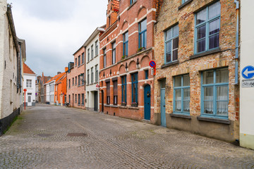 Old historical buildings along cobbled street in Bruges, Belgium