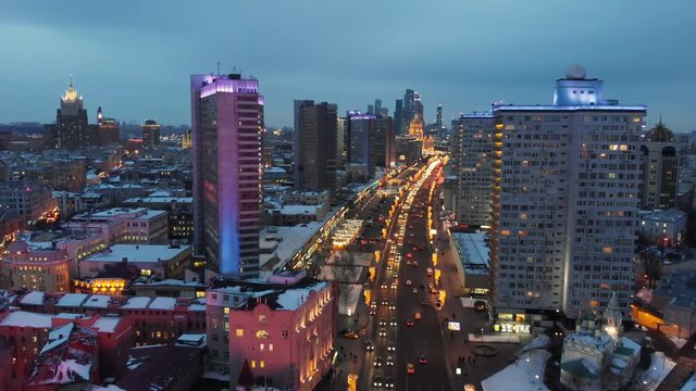 Bright lights of night Moscow from bird's eye view. Intensive traffic at New Arbat street in the heart of the city. Multistory houses illuminated with neon lights on the sides of the wide avenue.