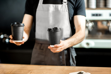 Barista holding coffee cups indoors