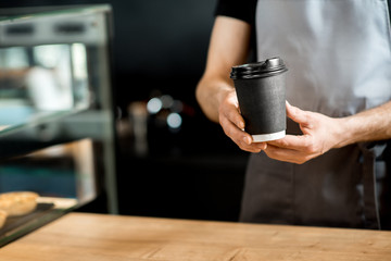 Fototapeta na wymiar Barista holding coffee cups indoors