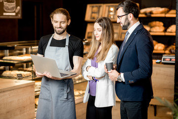 Business people with baarista in the pastry shop