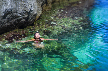 young attractive and happy Asian Korean woman in bikini swimming in amazing beautiful transparent sea water paradise at tropical beach lagoon enjoying
