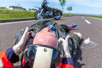 A german paramedic removes an helmet from an injured biker. Rettungsdienst is the german word for...