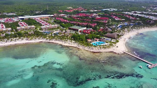 Aerial drone shot. Aerial view from above, birde eye view at an luxury resort hotel beach of a tropical coast. Turquoise water of the Caribbean Sea. Riviera Maya Mexico.