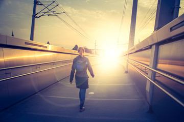 Obraz premium Junges Mädchen geht in den Sonnenuntergang, urban; Erfolg