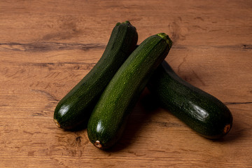 Fresh zucchinis on a wooden background