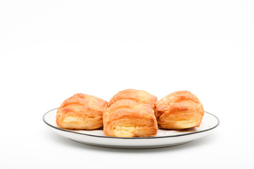 A plate of mini danish pastries with cheesecake shortcake fillings on white background with copy space.