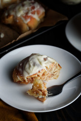 Sweet buns with a block and cinnamon on a dark background
