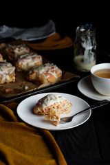 Sweet buns with a block and cinnamon on a dark background
