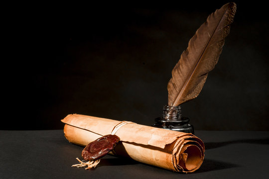 Scroll of a papyrus with a seal, a feather and an inkwell