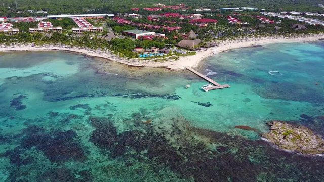 Aerial drone shot. Aerial view from above, birde eye view at an luxury resort hotel beach of a tropical coast. Turquoise water of the Caribbean Sea. Riviera Maya Mexico.