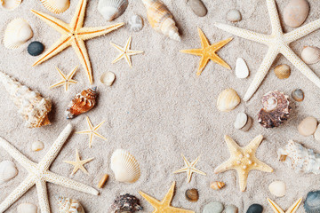Macro frame from starfish and seashell on sandy beach top view.