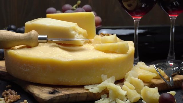 Video Whole round Head of parmesan or parmigiano hard cheese, grapes and wine