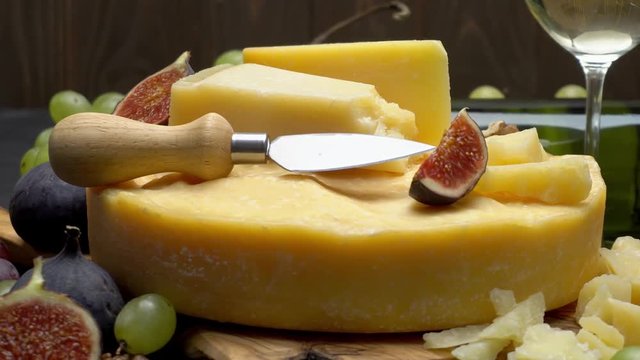 Video Whole round Head of parmesan or parmigiano hard cheese, grapes and wine