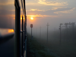 View from the window of the train in the yellow sun, red traffic lights and foggy morning © Вадим Анохин