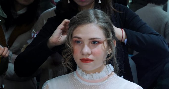 The hairdresser does a hairdress to beautiful model before photosession