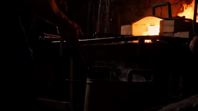 Hardening of the metal by sharp cooling in water. There is steam. The blacksmith tempers a red-hot sword on an old technology. Creation of ancient weapons. Blacksmith's Armory.