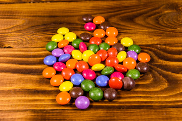 Fototapeta na wymiar Pile of the multicolored candies on a wooden table