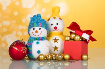 Two little funny snowman, Christmas toys, gifts and surprises, on yellow background