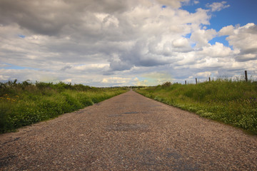 Asphalt road through the green field. Alentejo, Portugal